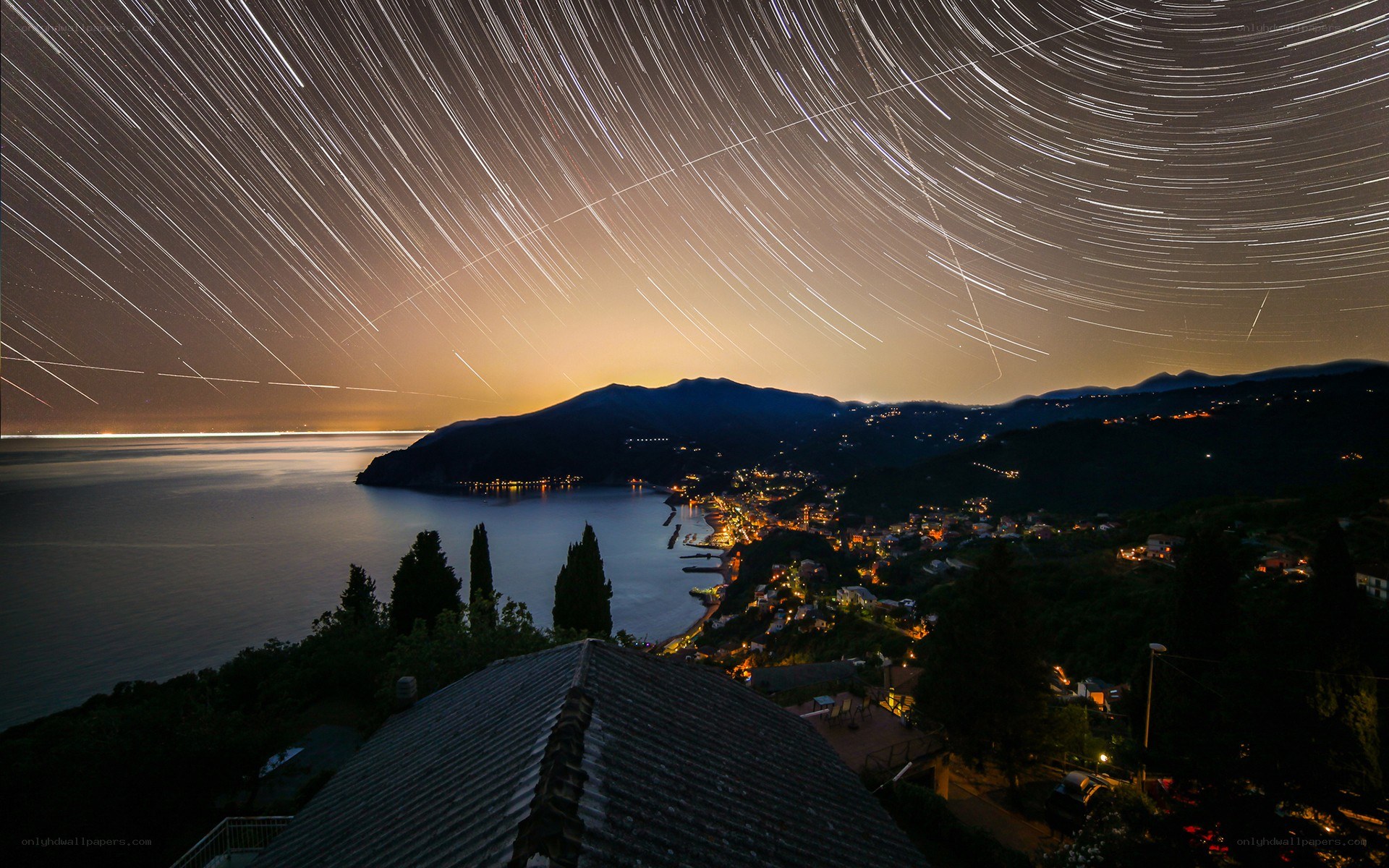 Star trails over coastal town