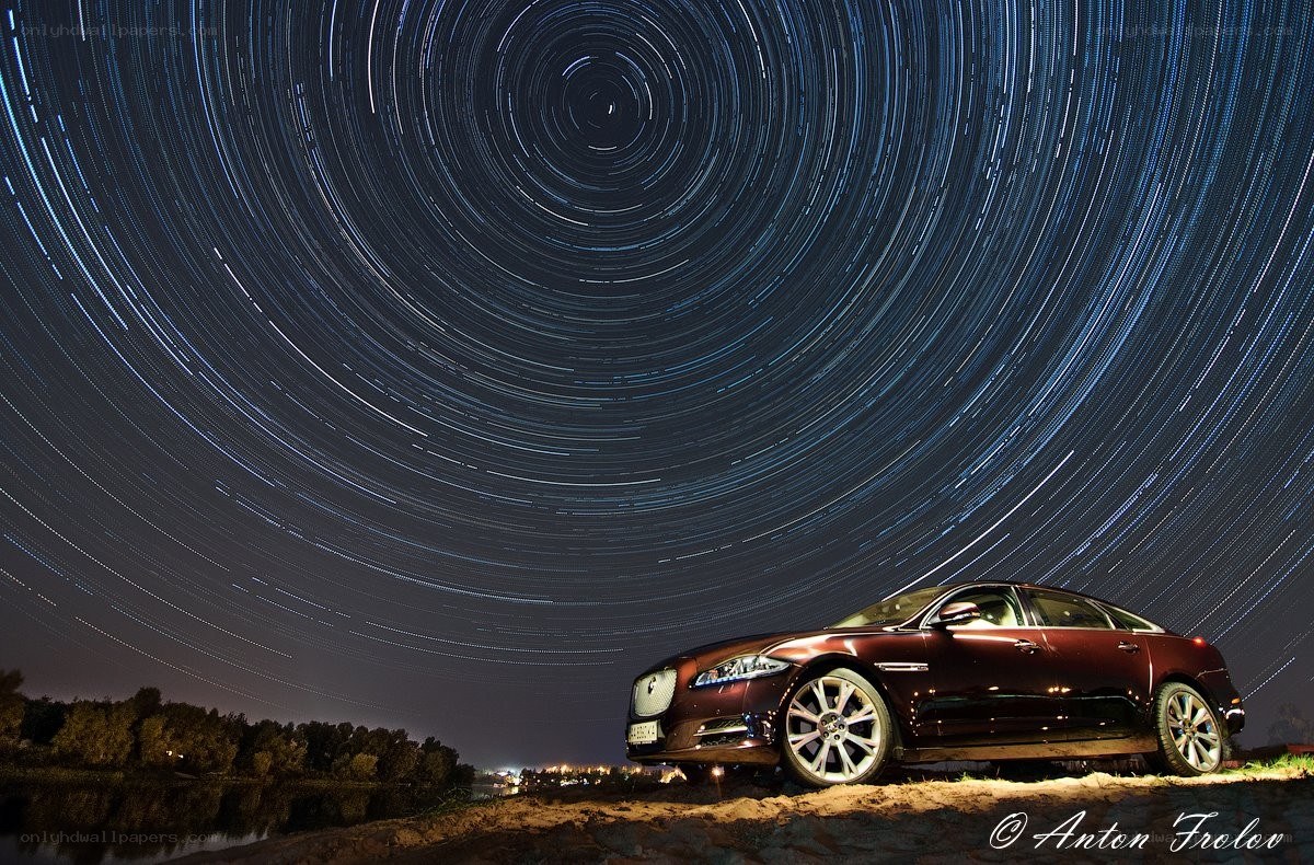 Star trails over luxury car