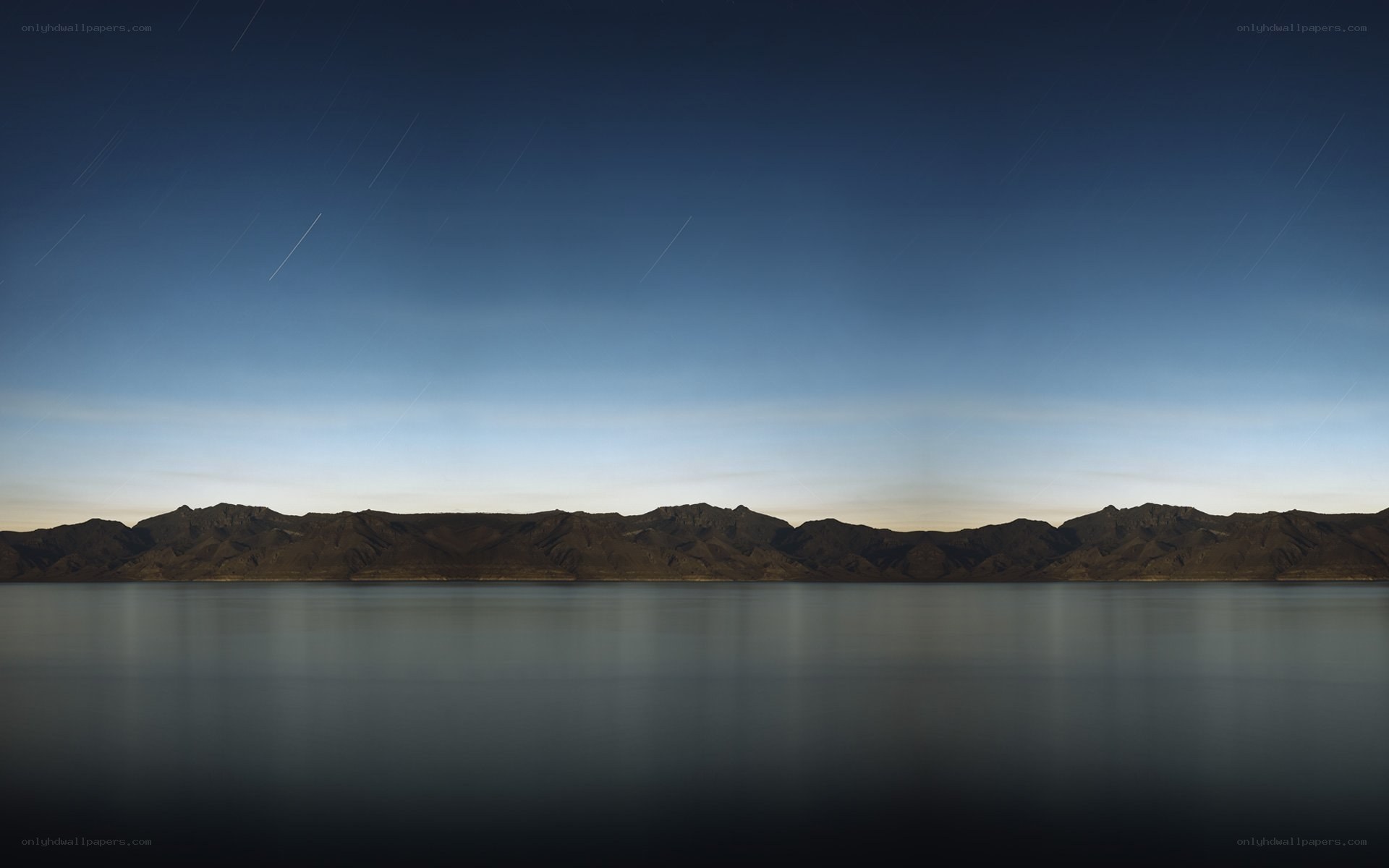 Star trails over mountain lake
