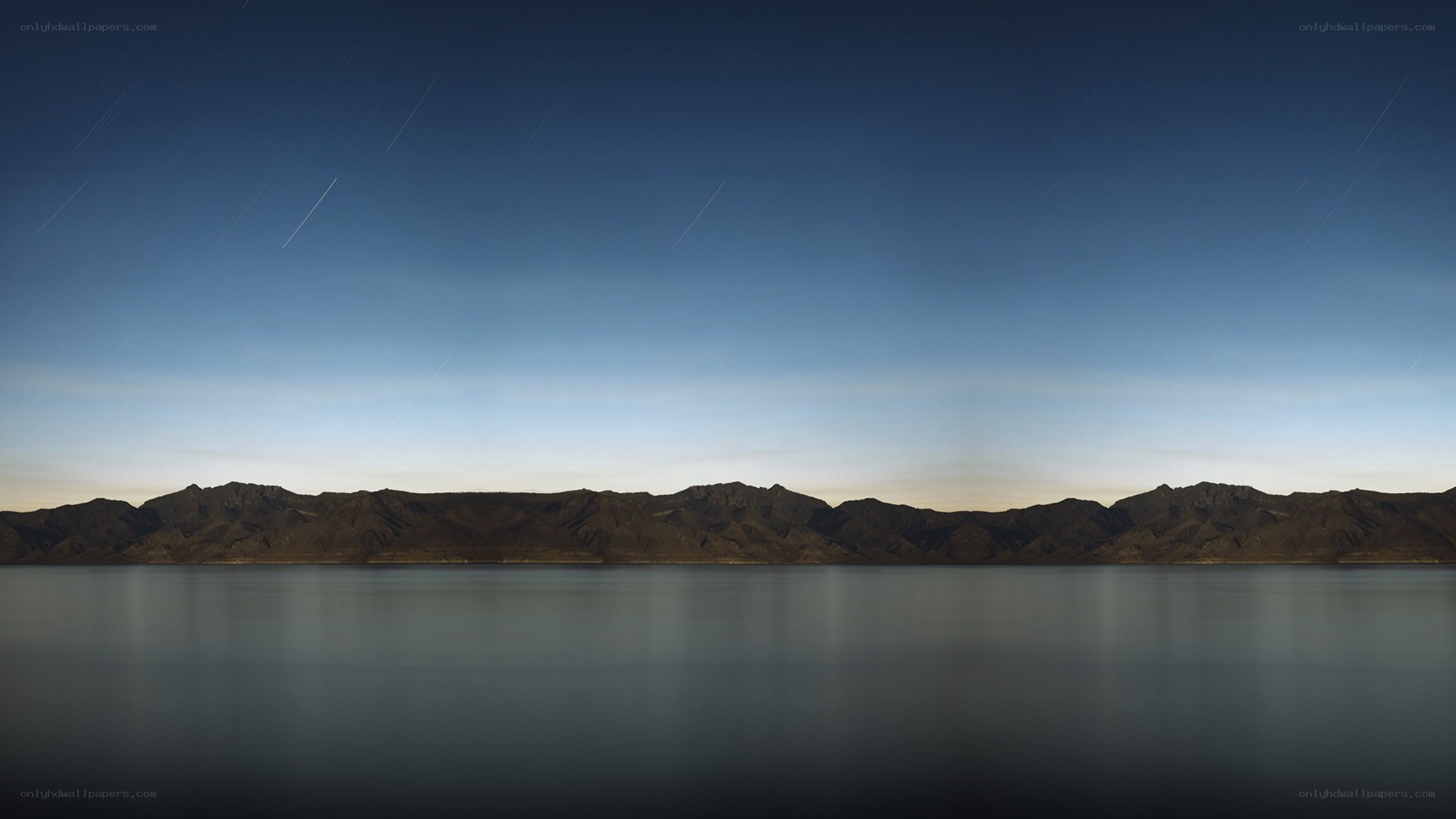 Star trails over mountain lake