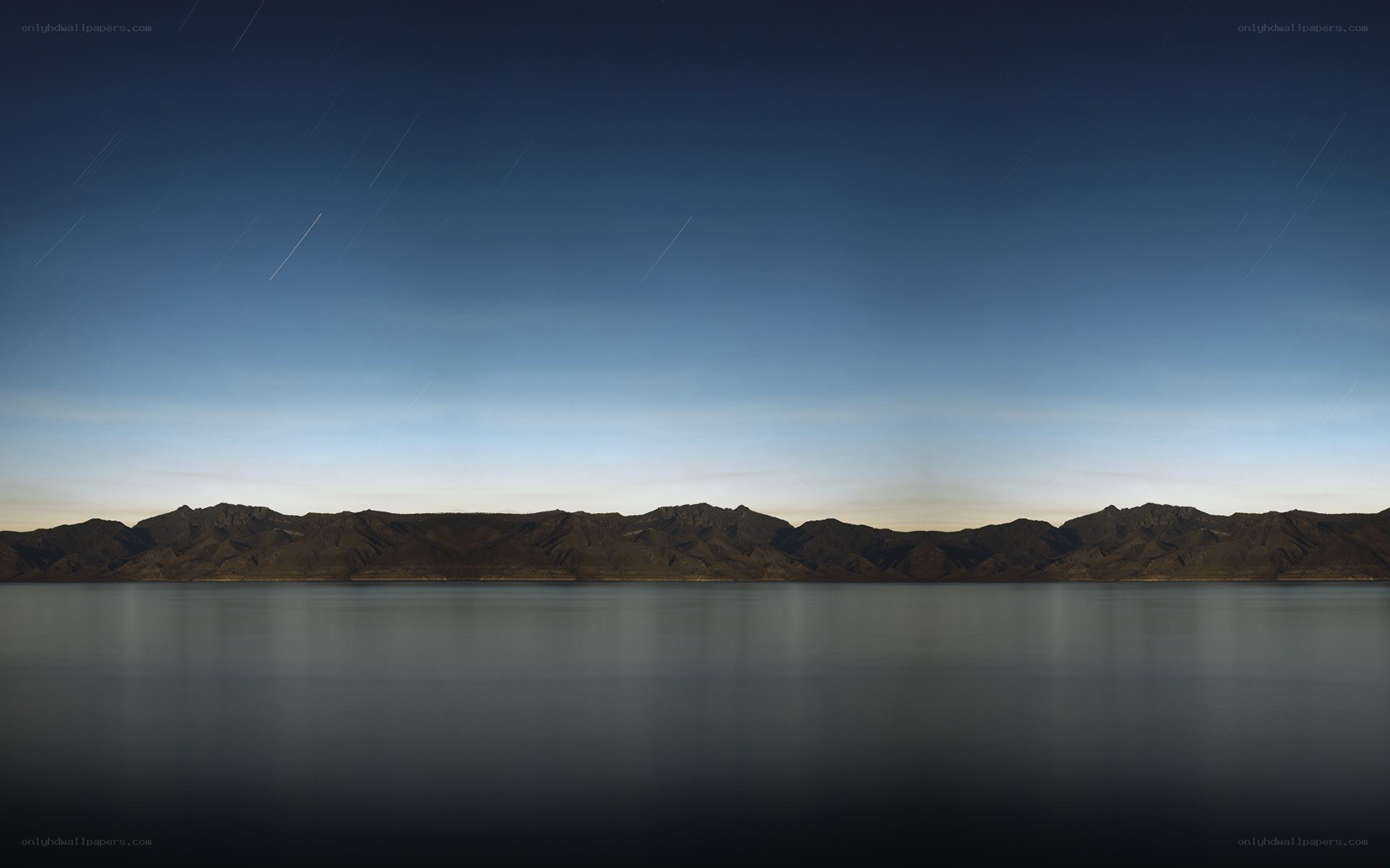 Star trails over mountain lake