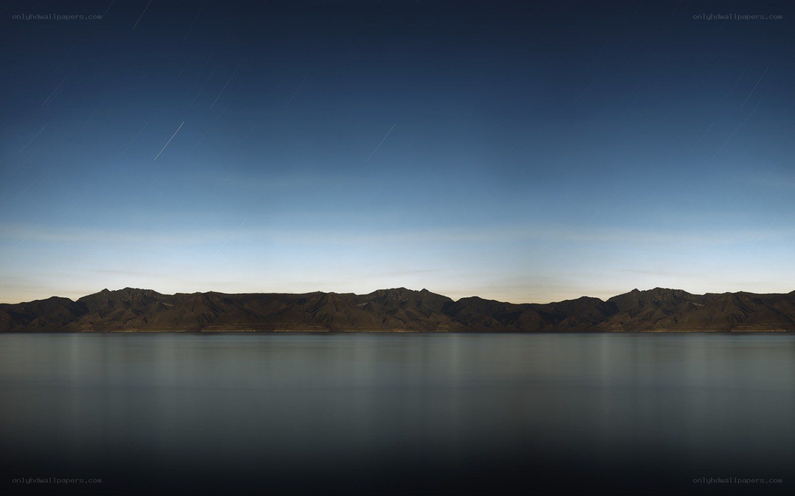 Star trails over mountain lake