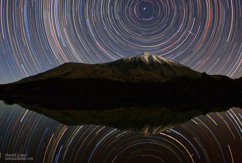 Star trails over mountain lake