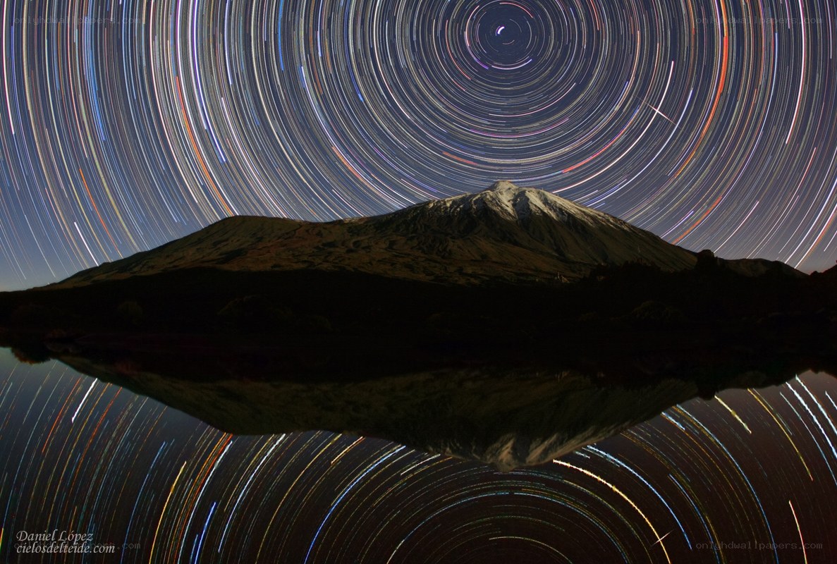 Star trails over mountain lake