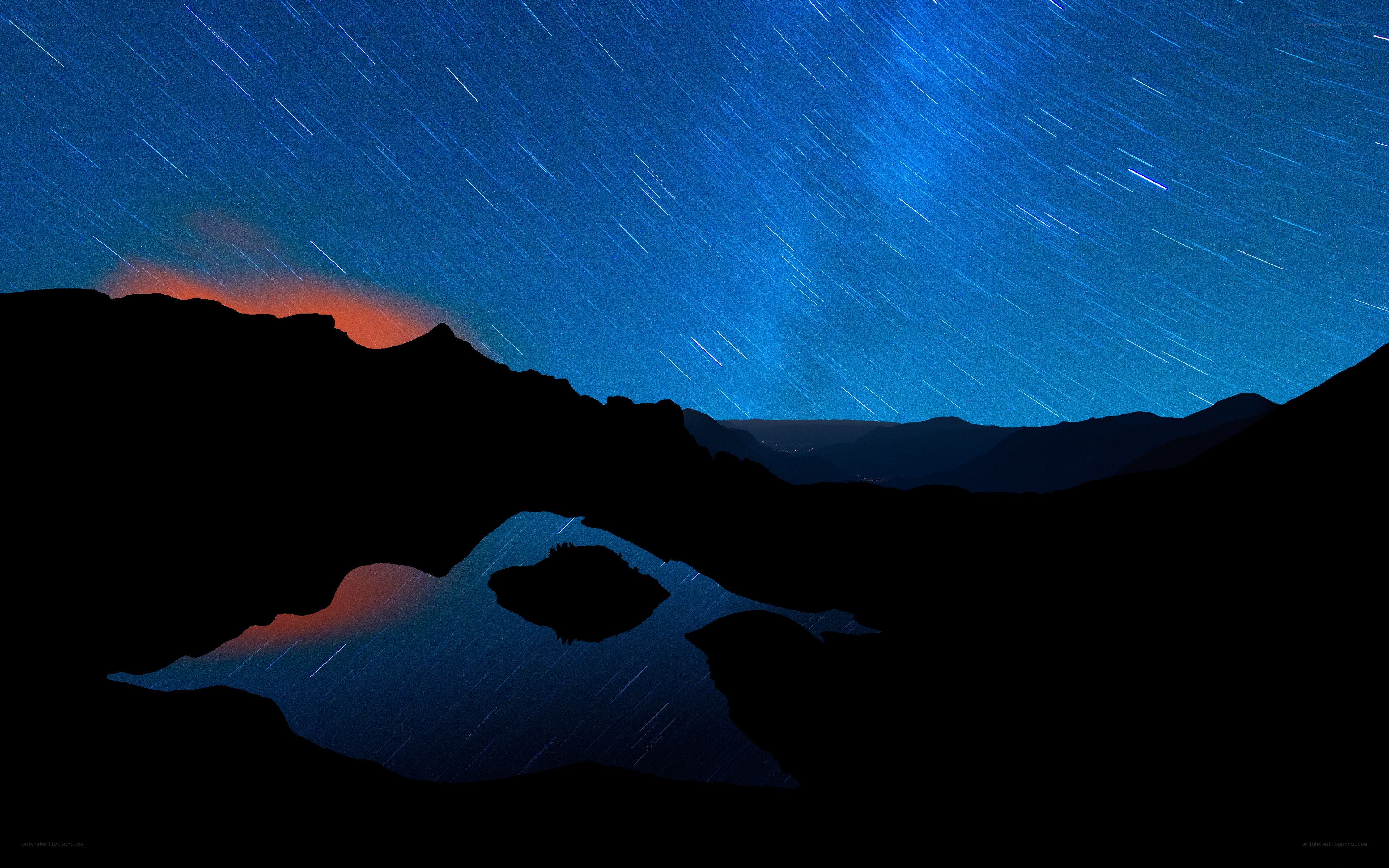 Star trails over mountain lake