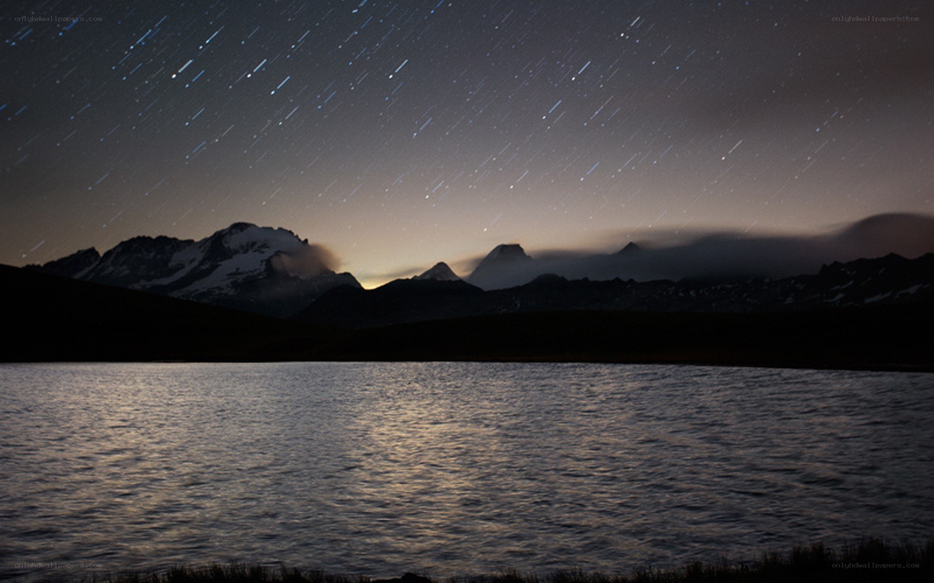 Star trails over mountain lake