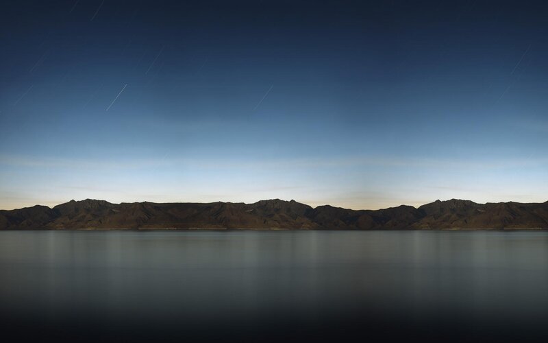 Star trails over mountain lake