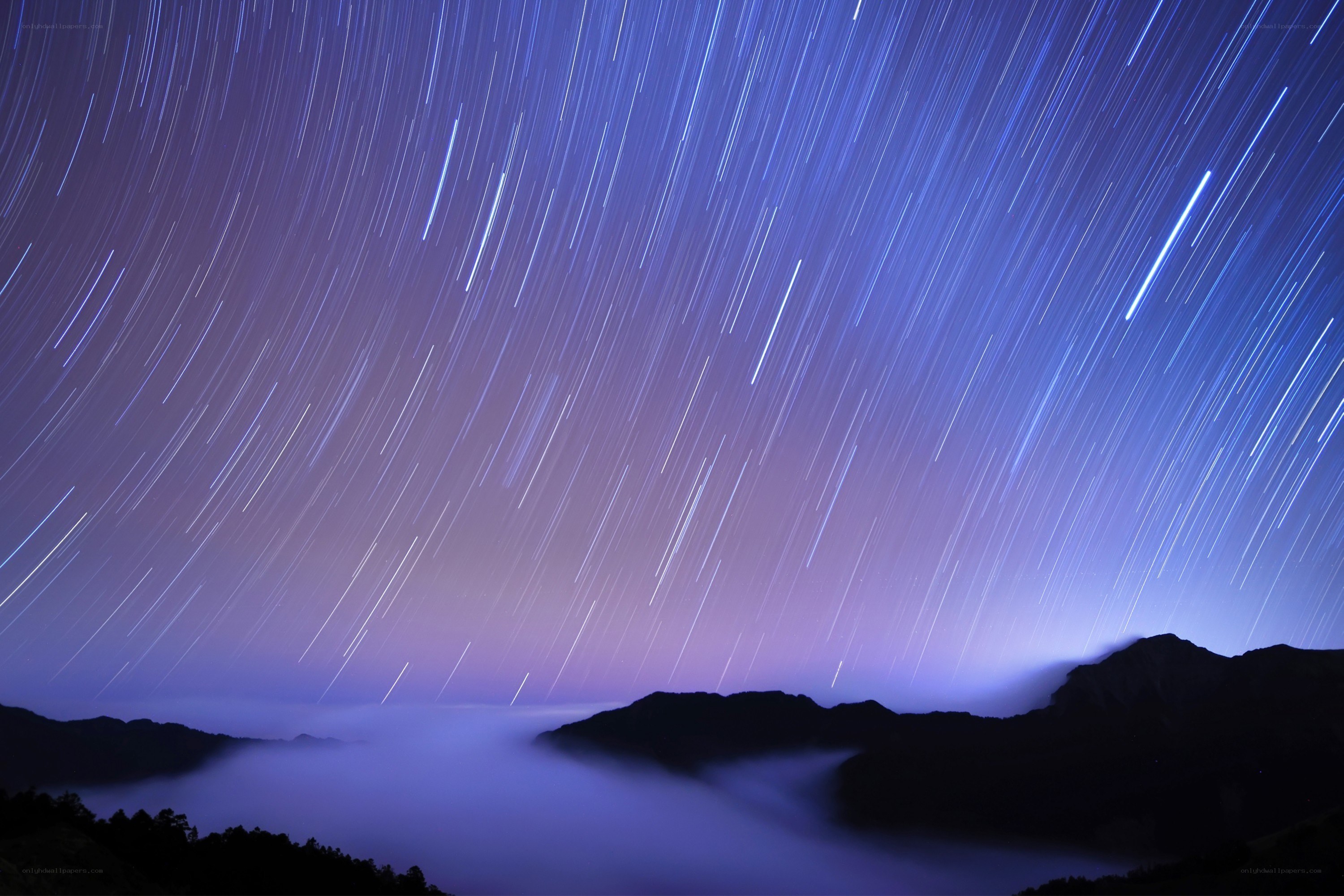 Star trails over mountain peaks