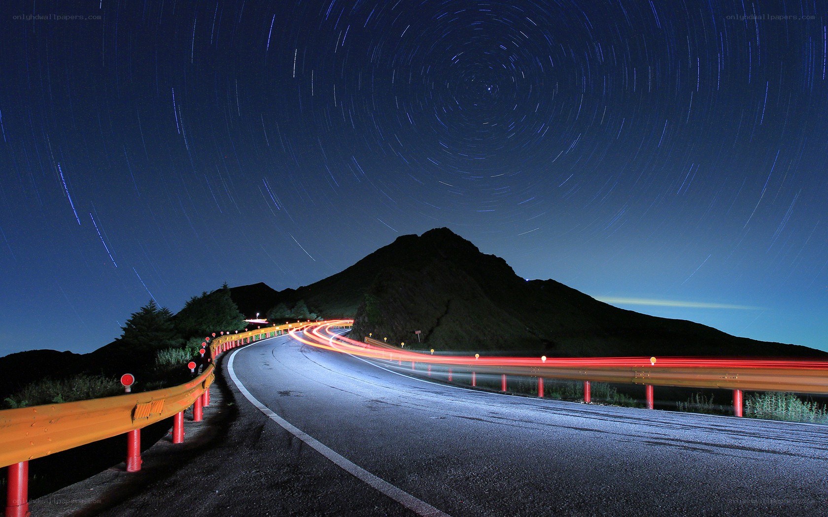 Star trails over mountain road