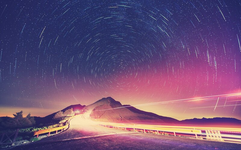 Star trails over mountain road