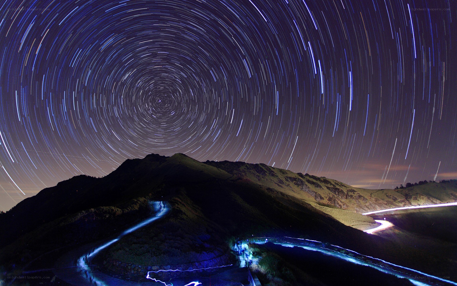 Star trails over mountain road