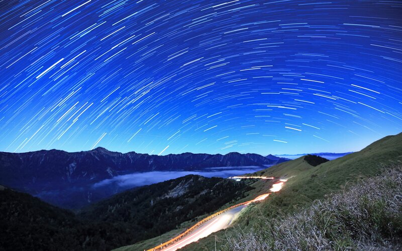 Star trails over mountain road