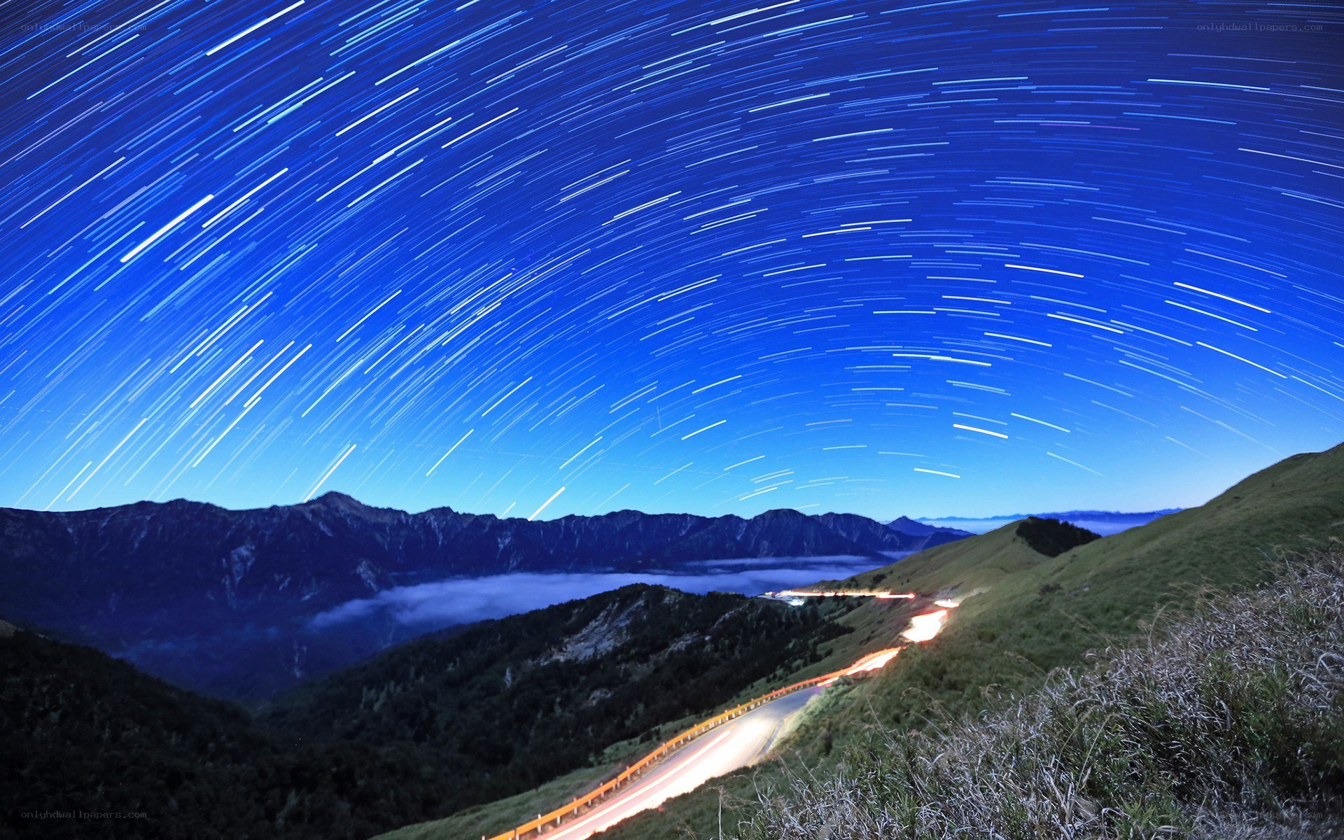 Star trails over mountain road