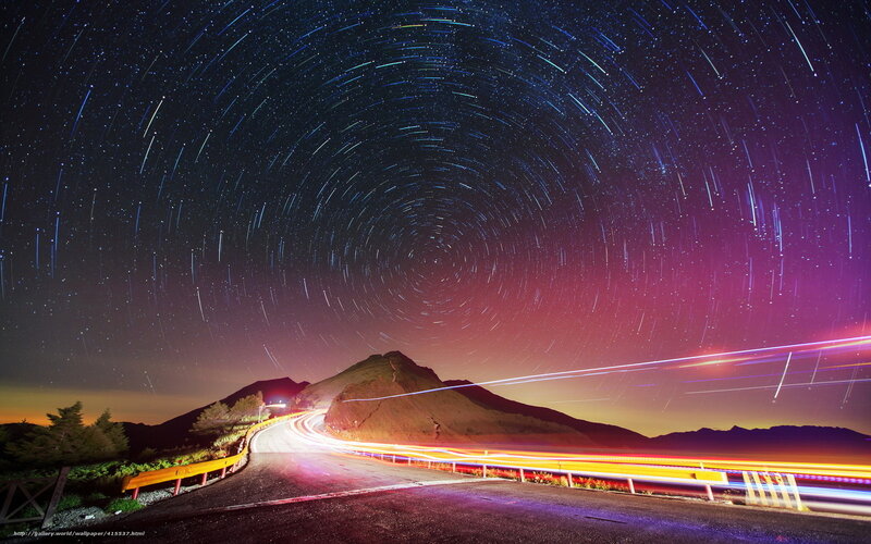Star trails over mountain road