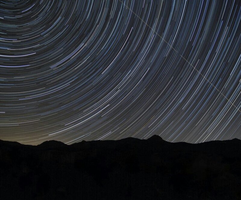 star trails over mountain silhouette