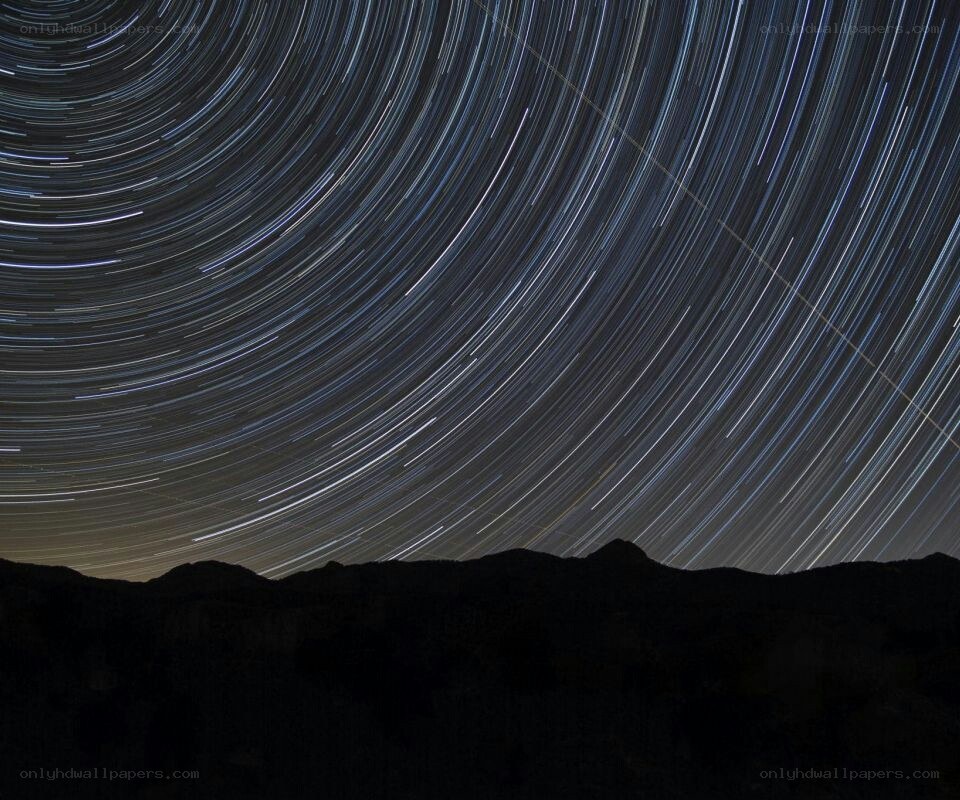 star trails over mountain silhouette