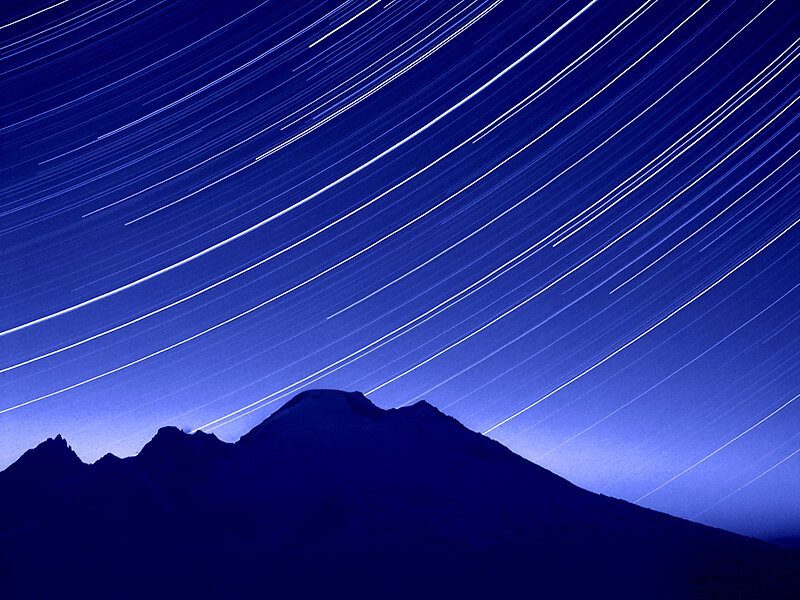 Star trails over mountain silhouette