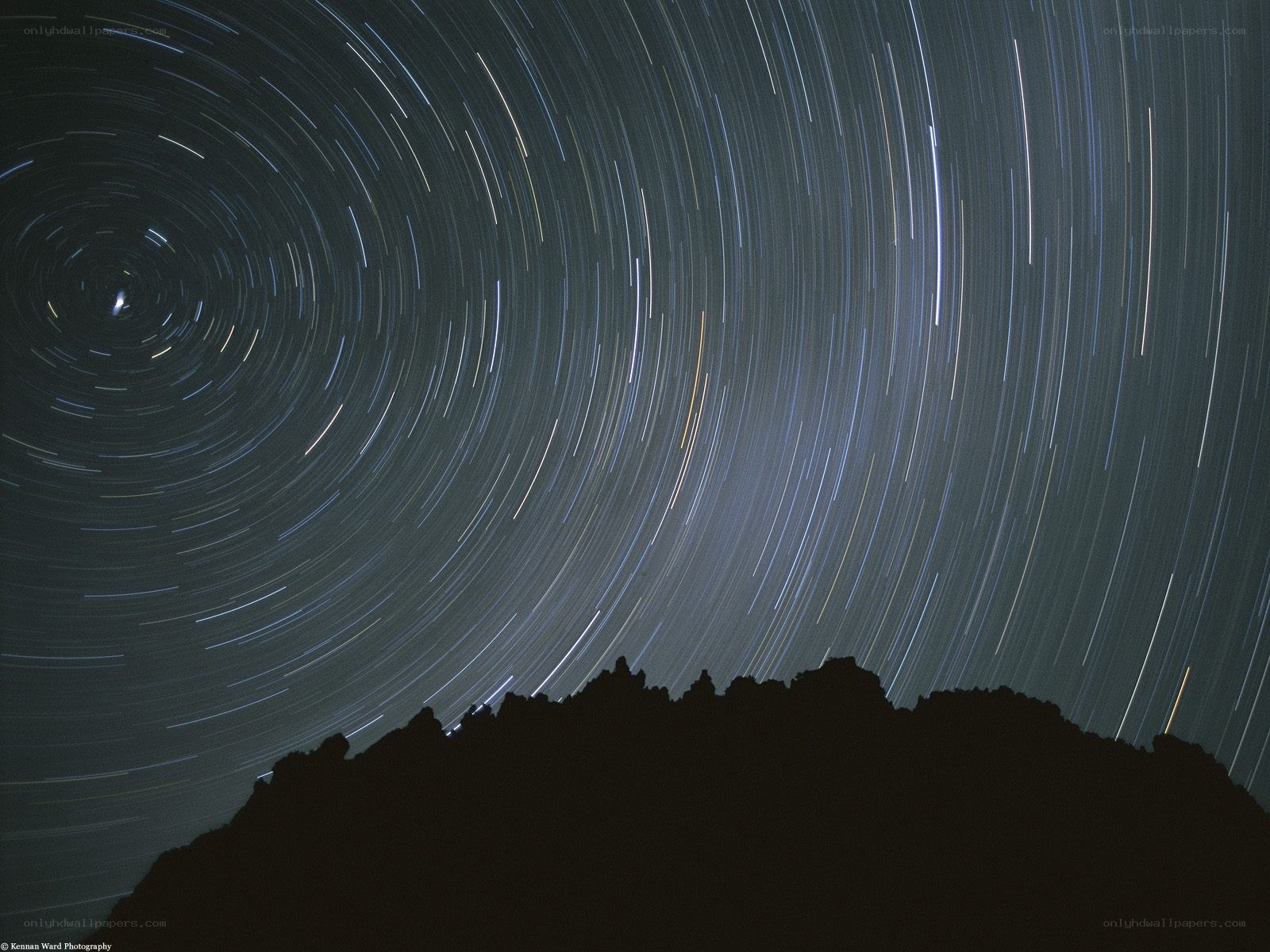 Star trails over mountain silhouette