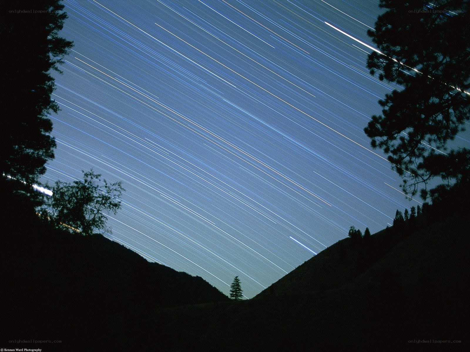 Star trails over mountain valley