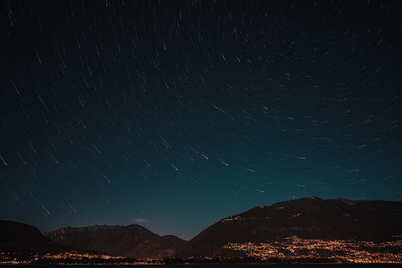 Star Trails over Mountains — Black, Serene, Night, Photograph, City Lights