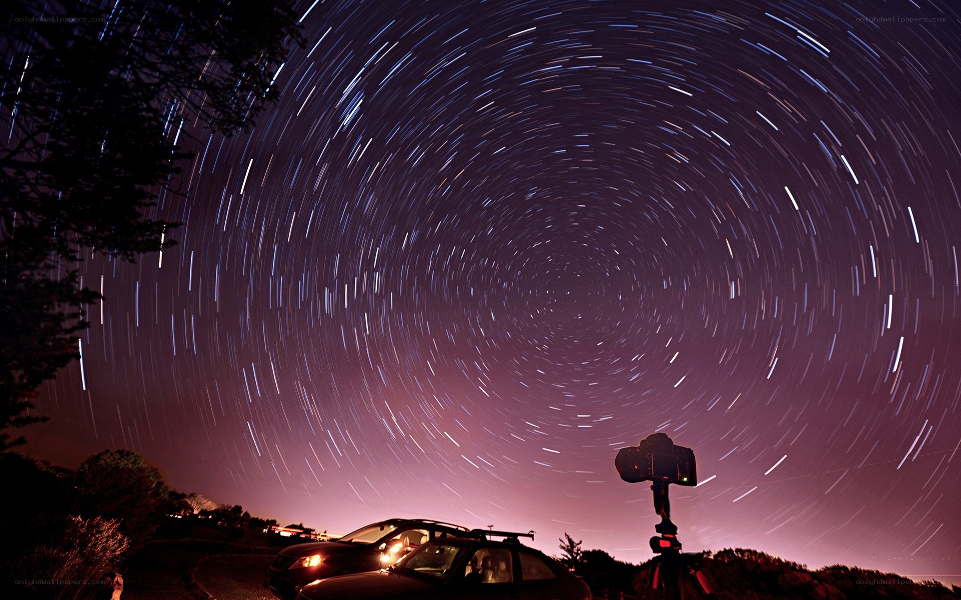 Star trails over parked cars