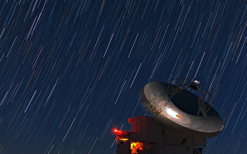 Star trails over radio telescope
