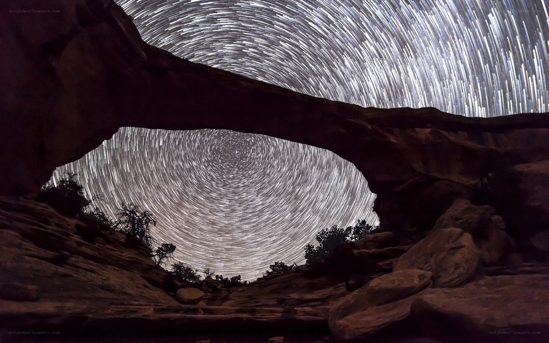 Star trails over rock arch
