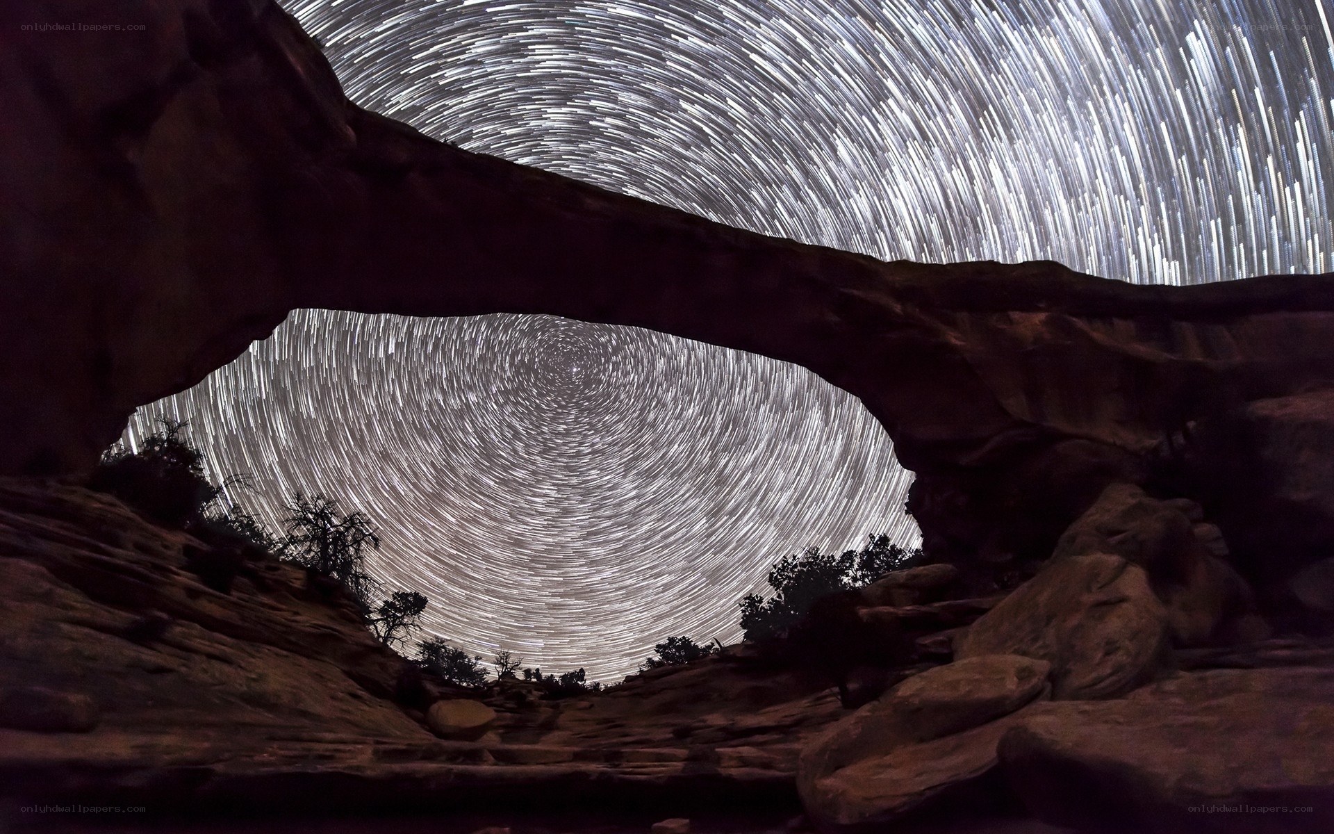 Star trails over rock arch