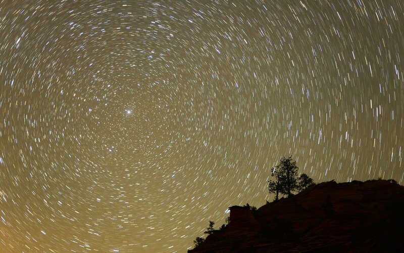 Star trails over rocky hill