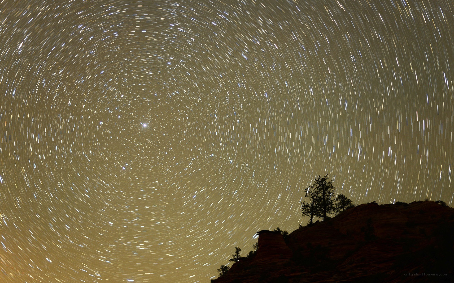 Star trails over rocky hill