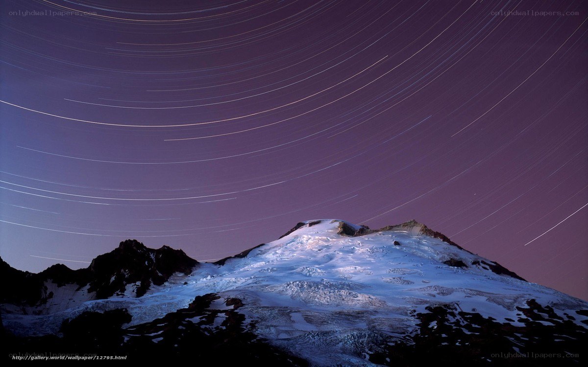 Star trails over snow-capped mountain