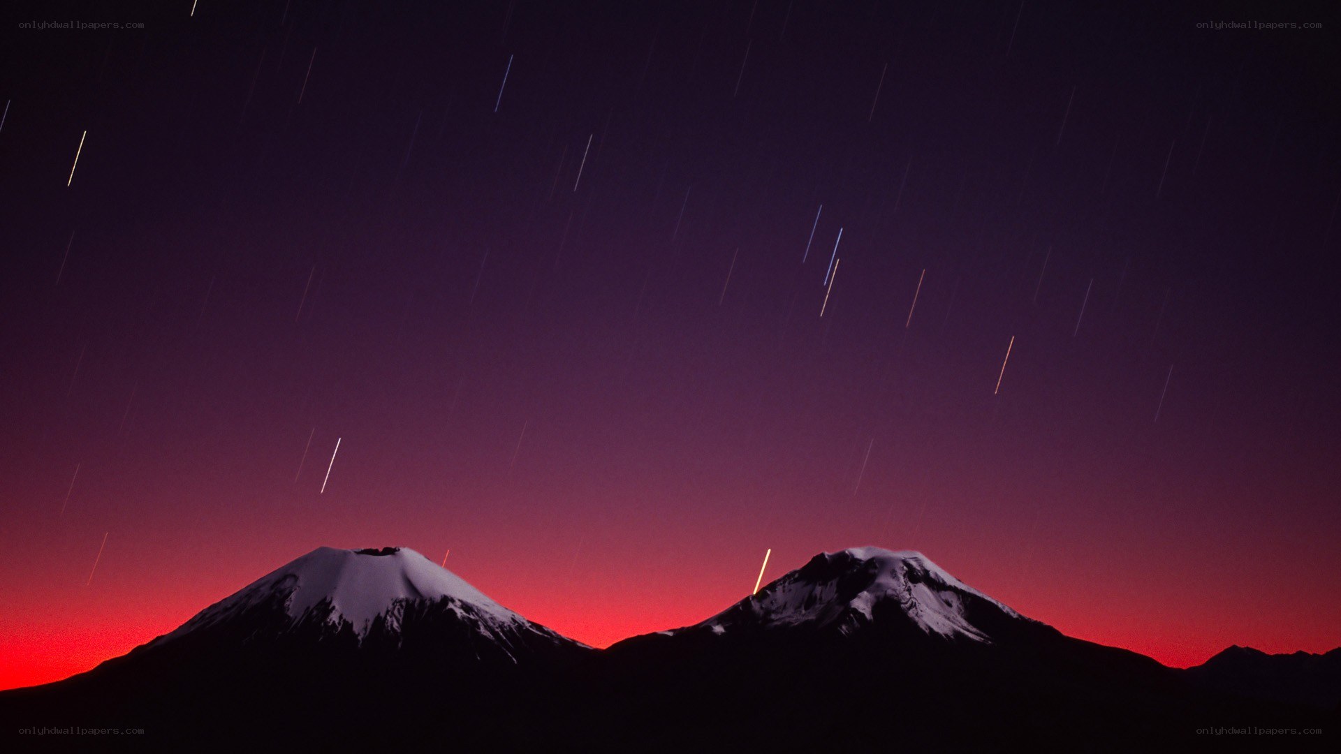 Star trails over snow-capped mountains