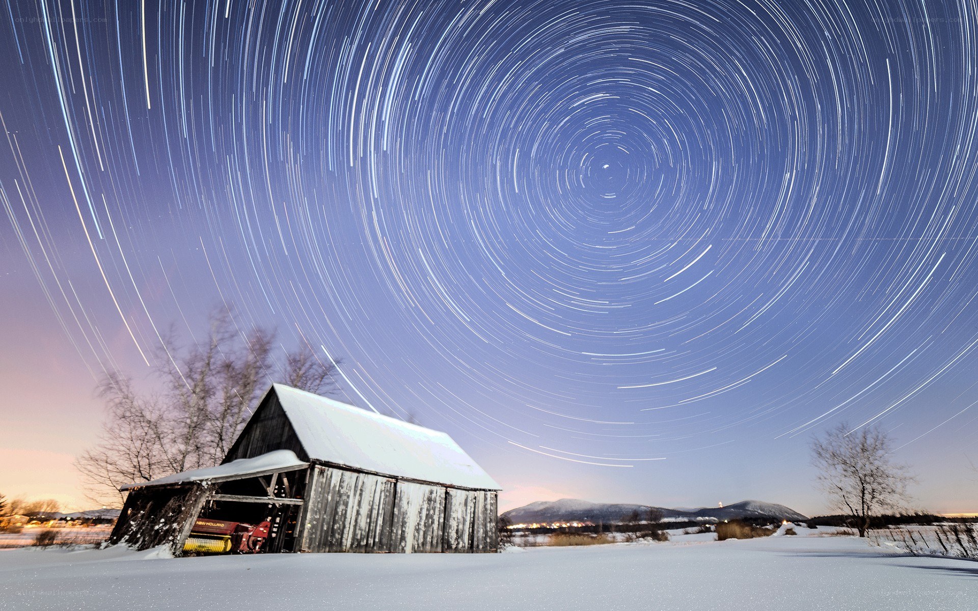 Star trails over snowy barn