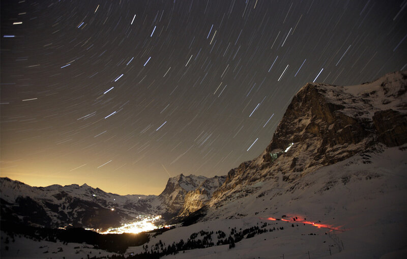 Star trails over snowy mountains
