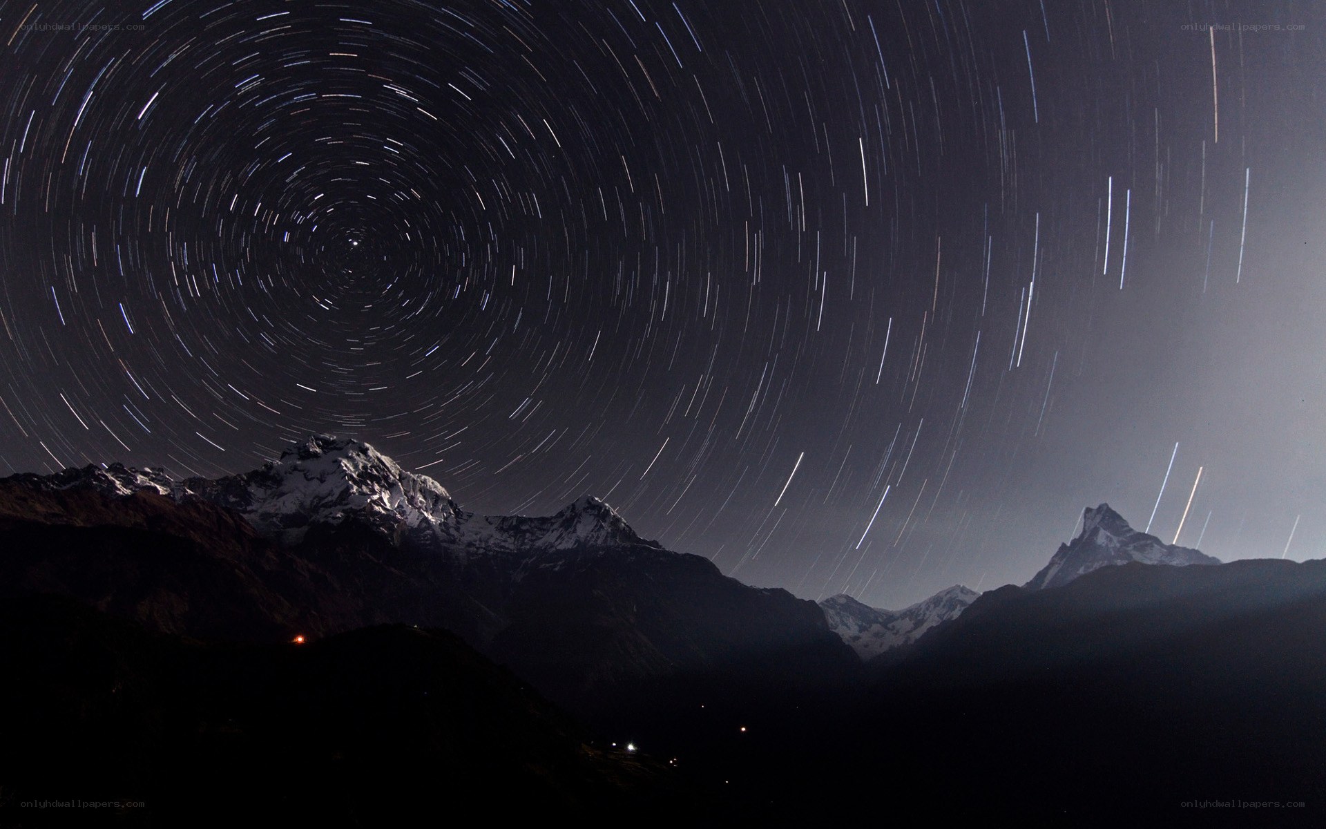 Star trails over snowy mountains