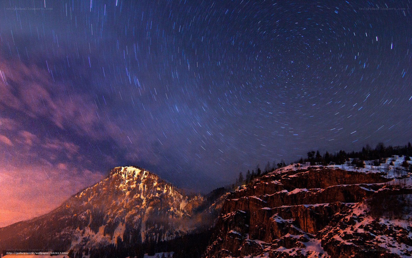 Star trails over snowy mountains