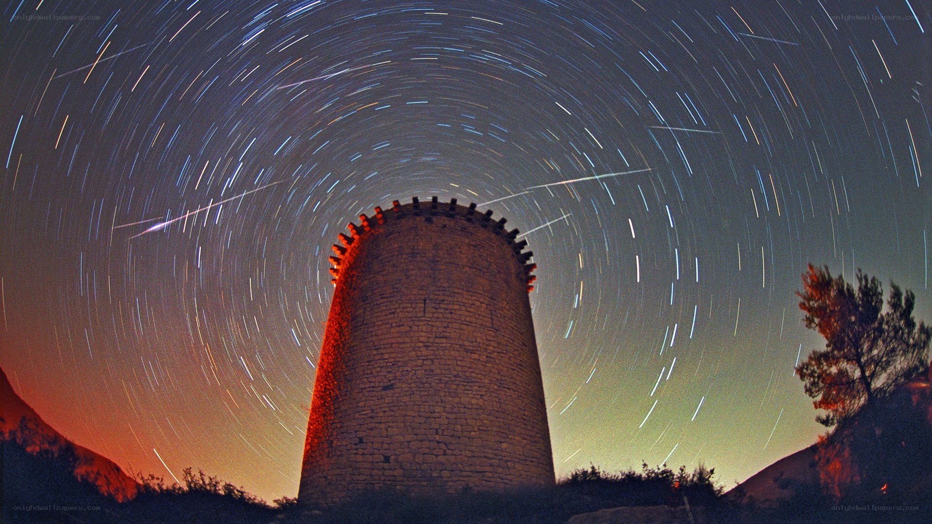 Star trails over stone tower