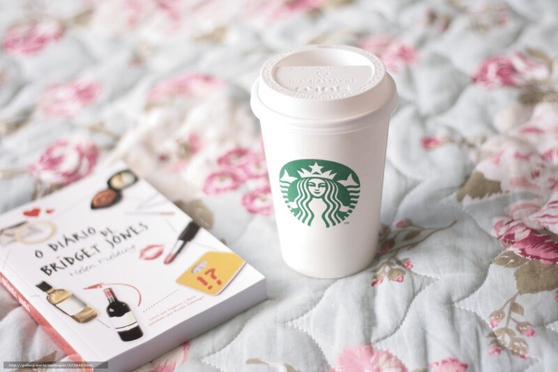 Starbucks cup and book on bed