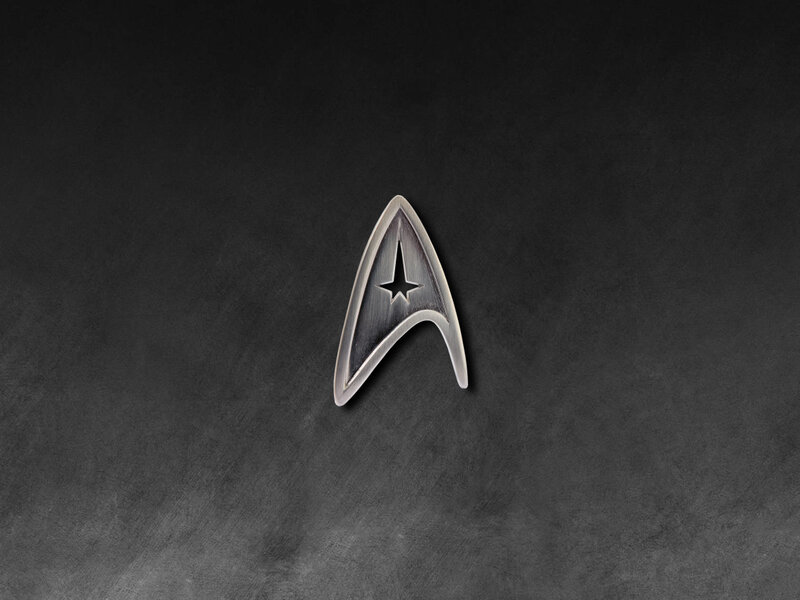 Starfleet insignia on dark background