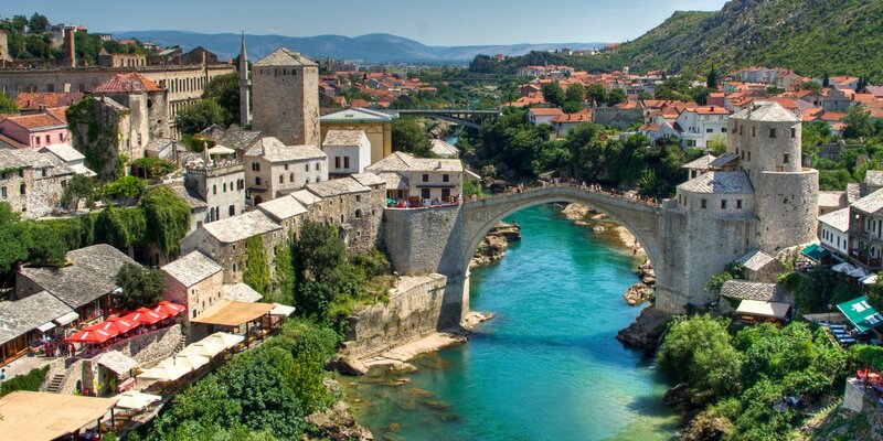 Stari Most Bridge — Blue, Serene, Afternoon, Photograph, River, Buildings, Mountains