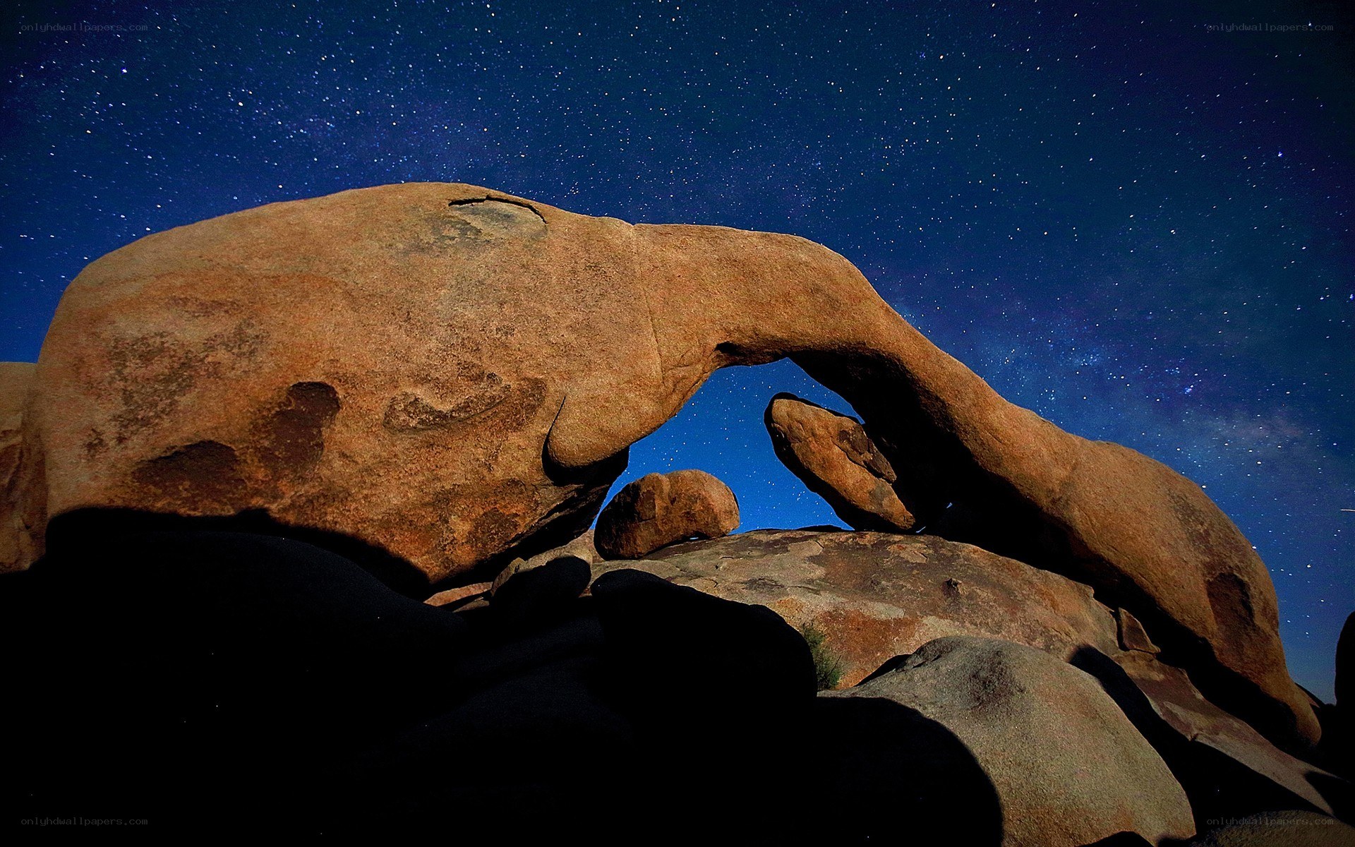 Starlit rock arch at night