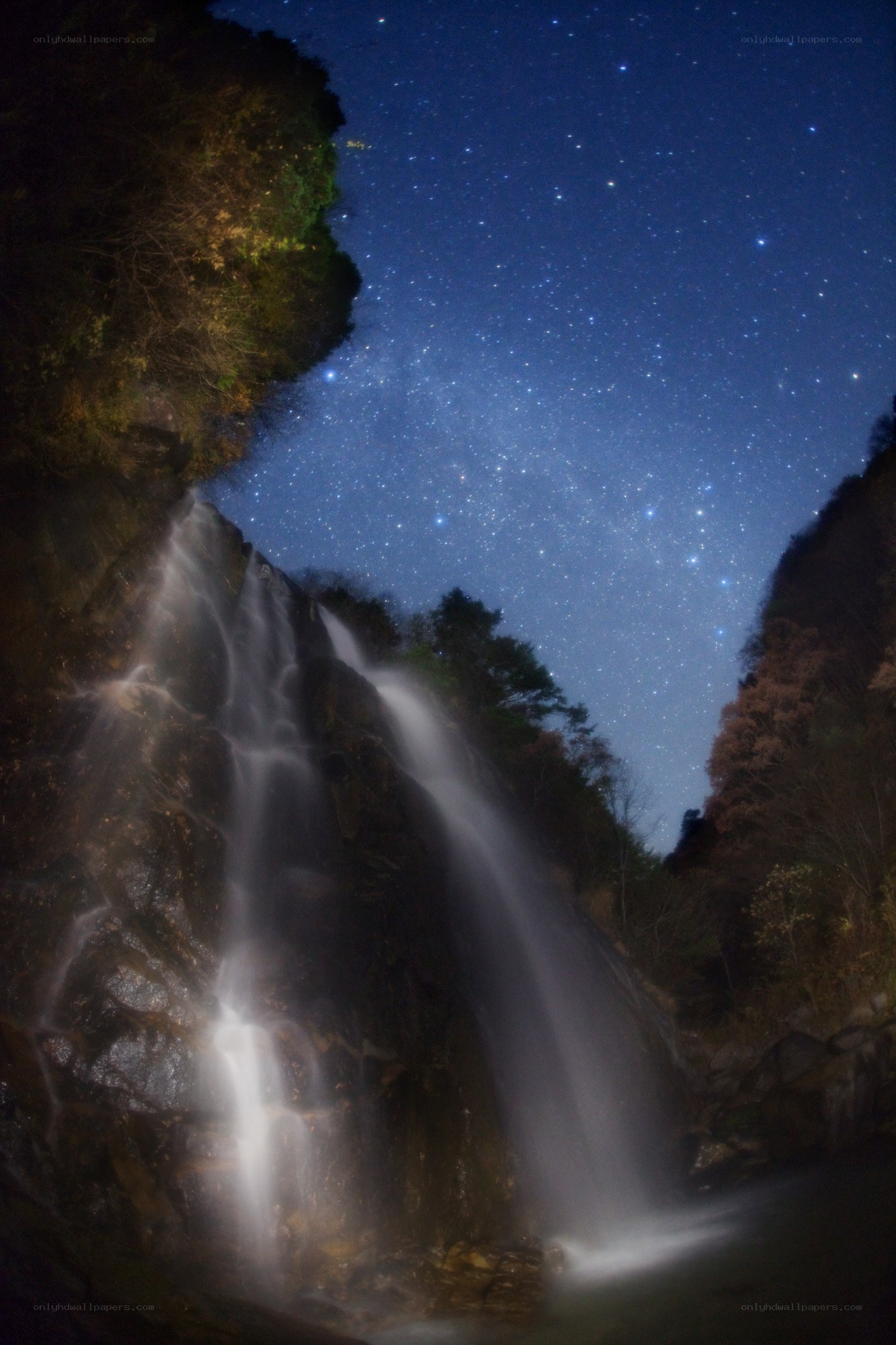Starlit waterfall at night