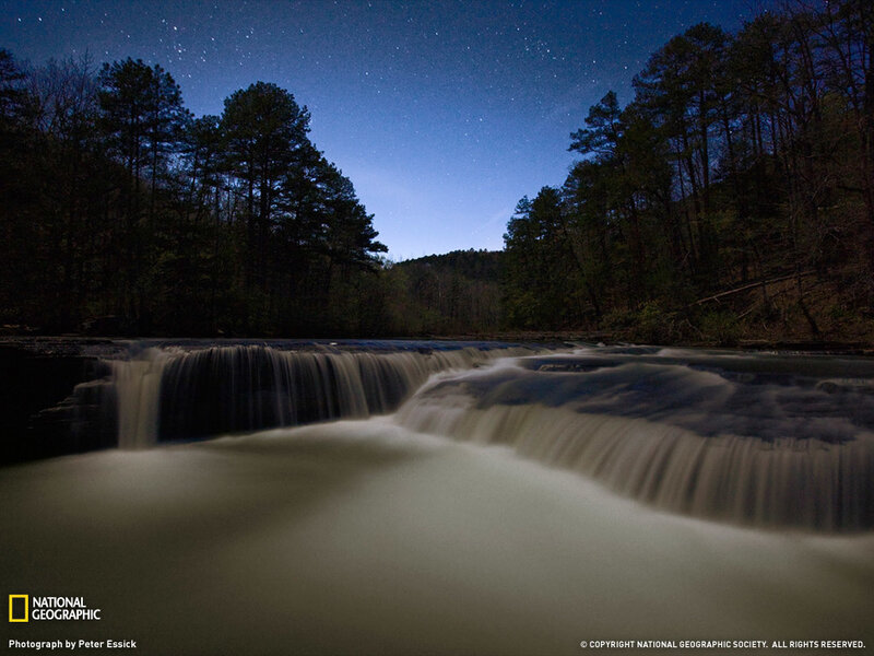 Starlit waterfall at night