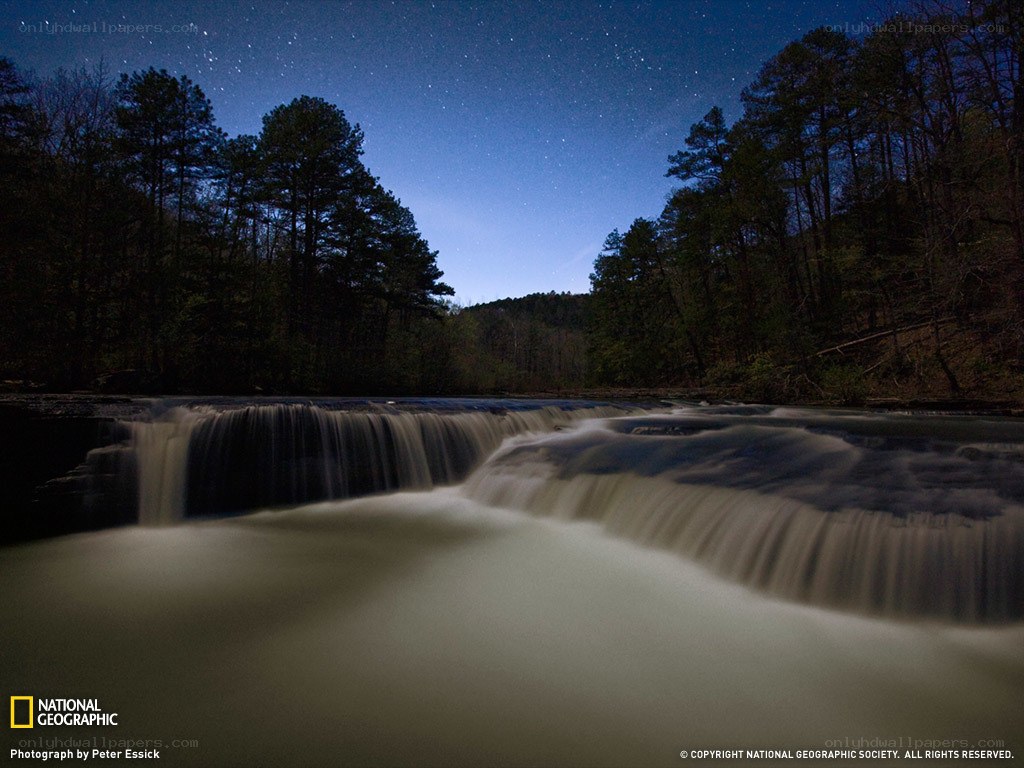Starlit waterfall at night