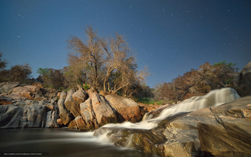 Starlit waterfall at night