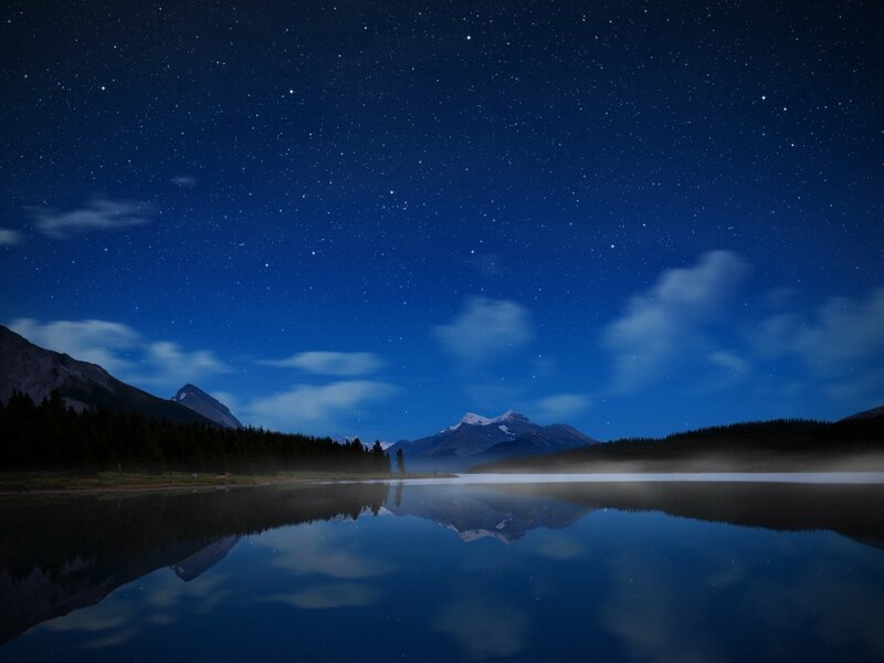 Starry night over a mountain lake