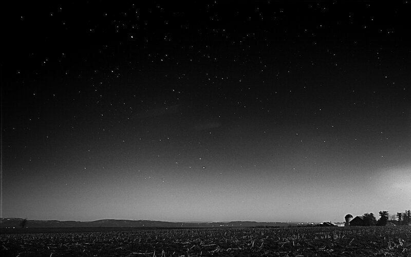Starry night over a rural field