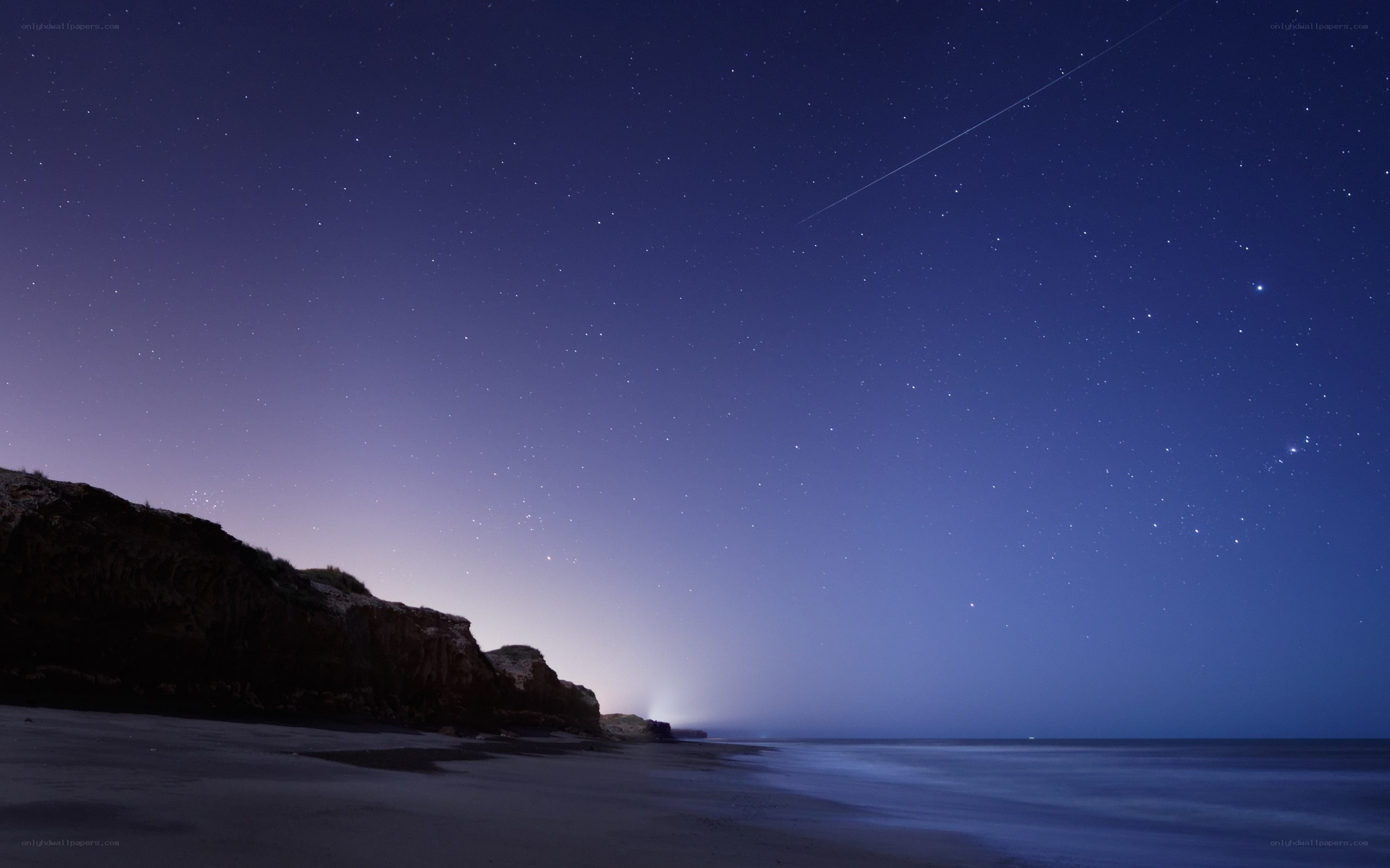 Starry night over coastal cliffs