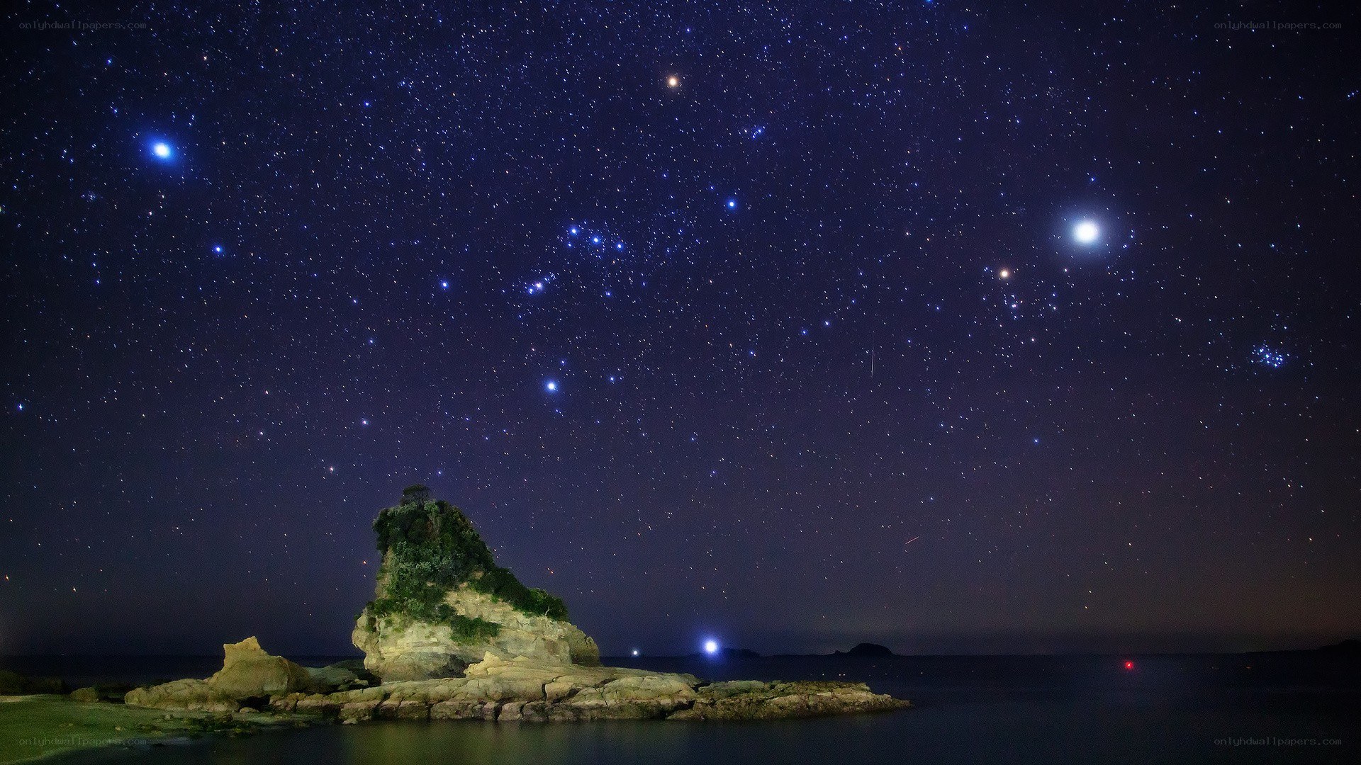Starry night over coastal rock