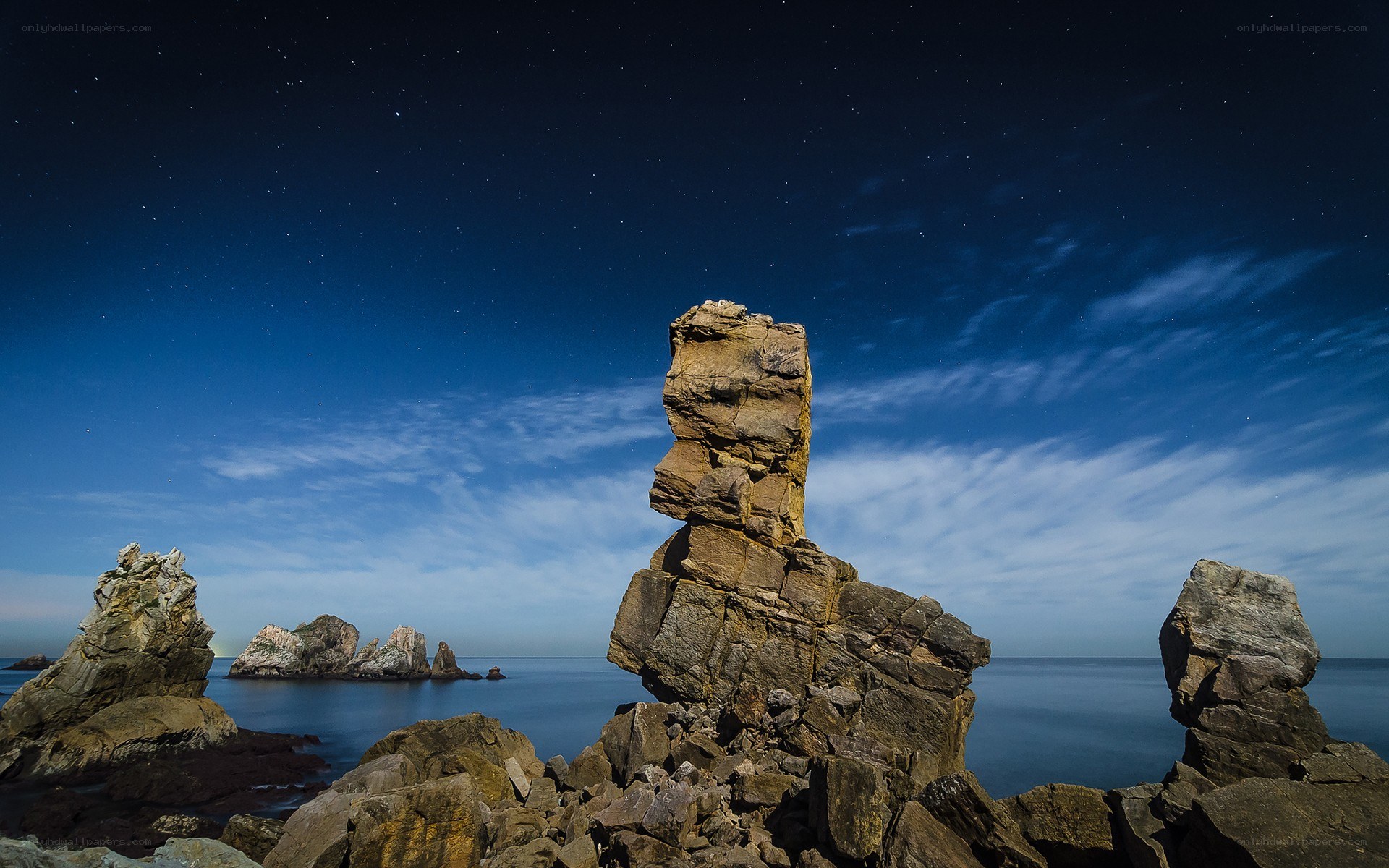 Starry night over coastal rocks